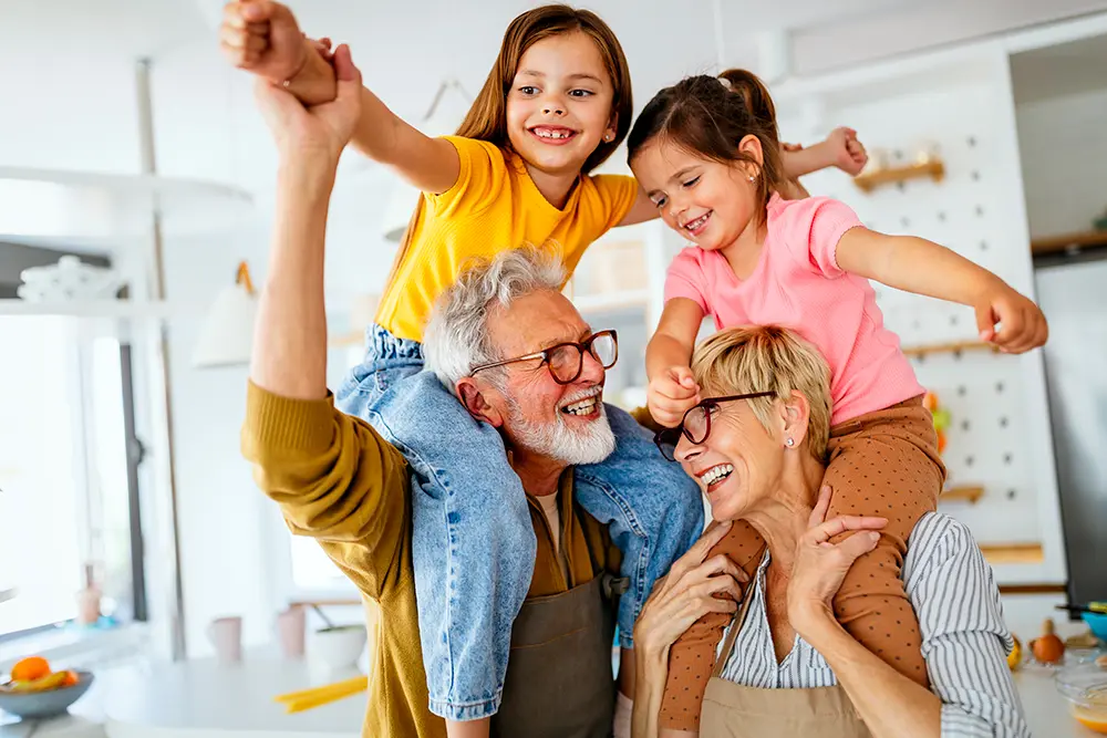 Happy gran parents with gran kids on their shoulders having a good time